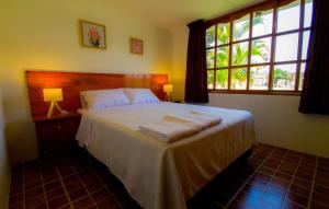 伊察Casa Solaris的一间卧室配有一张带白色床单的床和一扇窗户。