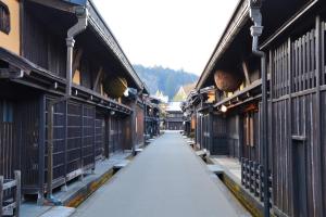 高山桜丸 Sakuramaru的两栋建筑之间有栅栏的空洞小巷