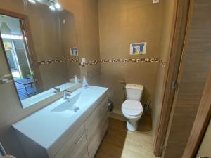 圣马丁德拉韦加Casa Simba la mejor opción para ver la Warner Bros的一间带卫生间、水槽和镜子的浴室