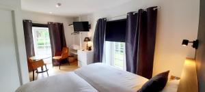 斯帕La Ferme du Soyeuru的一间卧室配有一张床、一张书桌和一个窗户。