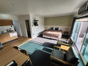 新普利茅斯斯特兰德汽车旅馆的卧室配有一张床和一张桌子及椅子