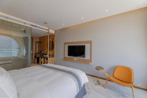 鱼池乡日月潭鸿宾大饭店的一间卧室配有一张床、一把椅子和电视。