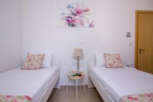 KathianaCasa Magnolia的白色墙壁客房的两张床