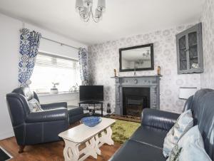 霍利黑德Trewan Cottage的带沙发和壁炉的客厅
