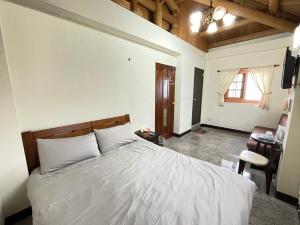 北竿芹壁山城民宿 Chinbe Hill Village House B&B的卧室配有一张白色大床和一张书桌