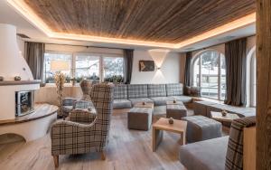 奥蒂塞伊Alpenheim Charming & Spa Hotel的客厅配有沙发和椅子