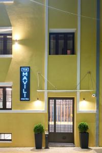 塞萨洛尼基The Mavili urban stay的黄色的建筑,旁边标有标志
