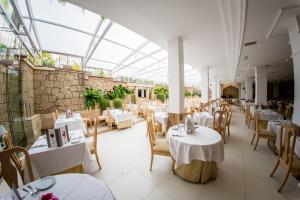阿德耶Apartamentos Parque del Sol的餐厅设有白色的桌椅和玻璃天花板