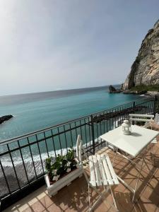 梅塔Residenza Mare di Sotto Sorrento的俯瞰大海的阳台配有桌椅