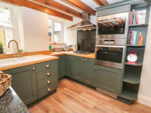里士满Hutchinson House的厨房配有绿色橱柜和水槽