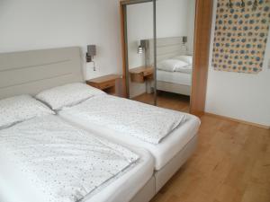 Attnang-PuchheimJOHN’S MOTEL APPARTEMENTHAUS的一间卧室配有两张床和镜子