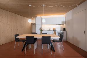 散特Chasa Laina的厨房以及带木桌和椅子的用餐室。