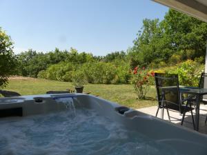 Castelnau-de-LévisPuech Evasion Détente avec SPA et Sauna privatifs à 10 min d'Albi的庭院内的热水浴池,配有桌椅