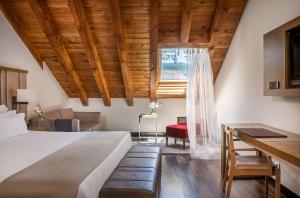 马德里帕拉西奥特帕NH精选酒店的一间卧室配有一张大床和一张书桌
