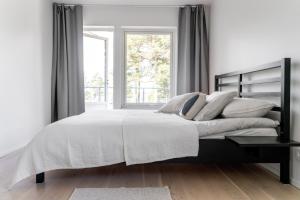 斯德哥尔摩Elegant home with stunning sea view and garden的白色的卧室设有一张大床和一个窗户