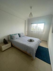 西迪拉哈尔Superbe appartement en résidence avec piscine的白色客房的一张床位,设有窗户