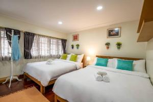 曼谷AT NANA-5Bed, CITY CENTER, Nana BTS, MBK, Central World, Siam的绿白色客房内的两张床