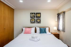 曼谷AT NANA-5Bed, CITY CENTER, Nana BTS, MBK, Central World, Siam的卧室配有一张带彩色枕头的大型白色床。