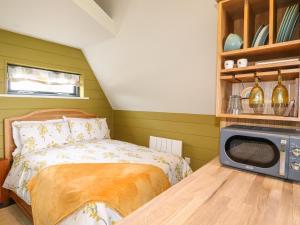 唐克斯特Buttercup Lodge的一间卧室配有一张床和一张桌子上的微波炉
