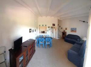 帕劳Le case di Stella Maris的客厅配有沙发和带蓝色椅子的桌子