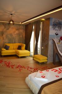 都拉斯Vila One Beach Hotel的客厅配有黄色沙发和鲜花,位于地板上