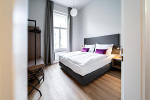布拉格Karl BY ZEITRAUM的一间卧室配有一张带紫色枕头的大床