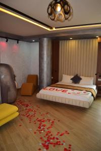 都拉斯Vila One Beach Hotel的卧室配有一张铺有红色鲜花的床。