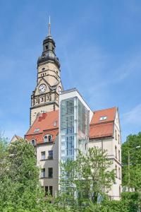 莱比锡Philippus Inklusionshotel Leipzig的一座高大的建筑,上面有一个钟楼