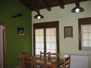 UdaveBalkonpe II的一间拥有绿色墙壁和桌椅的用餐室