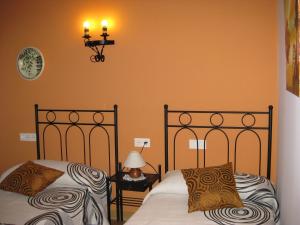 UdaveBalkonpe I的卧室设有两张床铺和橙色墙壁