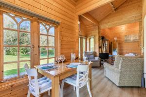 NeatisheadViolet Lodge - Norfolk Holiday Properties的小屋内带桌椅的用餐室