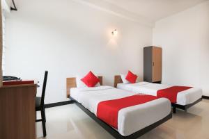 PīlameduFlagship 82361 Black Pearl Residency的两张位于酒店客房的床铺,配有红色枕头