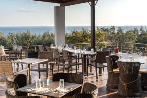 费马波尔特贝利撒留酒店的餐厅设有桌椅,以大海为背景