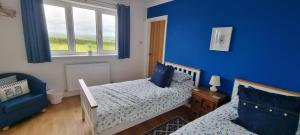 金斯布里奇Merrifield House Devon的一间卧室设有两张床和蓝色的墙壁