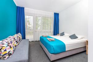 弗瓦迪斯瓦沃沃Ośrodek Wypoczynkowy CHAMPION的一间卧室设有两张床和蓝色窗帘
