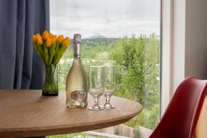 雷克雅未克Lundur Apartments的一瓶香槟和两杯带窗户的桌子