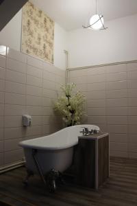 布加勒斯特有趣时光酒店的带浴缸和花瓶的浴室
