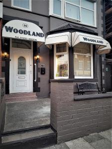 布莱克浦The Woodland Hotel的前面有长凳的林地商店