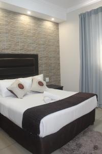 恩潘盖尼Bayside Hotel Empangeni的卧室配有一张带白色床单和枕头的大床。