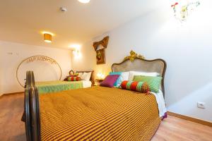 VidemonteCasa do Chefe的一间卧室配有两张带色彩缤纷枕头的床