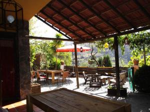 Quéntar丰达路西亚住宿加早餐旅馆的一个带桌子和红色遮阳伞的庭院