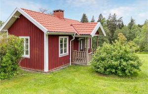 Stunning Home In Tranhult With Kitchen的草上红色屋顶的红色房子