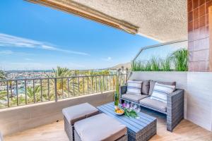阿尔库迪亚Ideal Property Mallorca - Blue Sky的阳台配有沙发和桌椅。