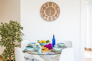 阿尔库迪亚Ideal Property Mallorca - Blue Sky的墙上一张带盘子的餐桌