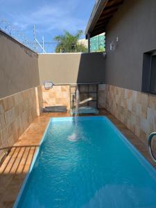 奥林匹亚Casa Thermas Olimpia I - 150 metros do Thermas dos Laranjais的一座房子前面带喷泉的游泳池