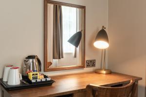 昆斯费里The Hawes Inn by Innkeeper's Collection的一张带镜子的桌子和一盏灯