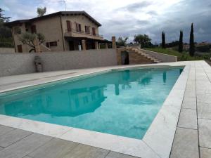 SpinetoliB&B L' Antica Fonte的房屋前的游泳池