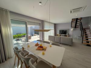 科济诺Zadar Premium Apartments的用餐室以及带白色桌椅的起居室。
