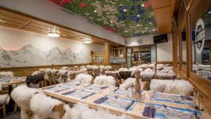 克莱纳谢德格斯海德格火车站餐厅山林小屋的一间设有白色桌椅和天花板的用餐室