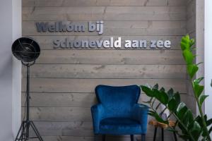 布雷斯肯斯EuroParcs Schoneveld的木墙边的蓝色椅子,上面写着被剪掉的很破旧的字眼